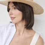 Women wearing a stylish short wig with a wide-brim straw hat.