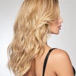 Blonde wavy wig styled on a woman with side profile view.