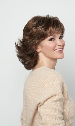 Woman with short layered brown wig smiling, showcasing Breeze wig style.