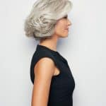Side view of a woman with a stylish silver wavy wig.