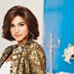 Woman with short, wavy brown wig wearing a gold sequin jacket.