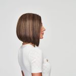 Side view of a woman with a sleek, straight brown bob wig.
