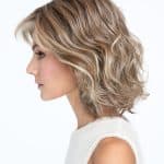 Blonde wavy wig styled on a woman for a natural look.