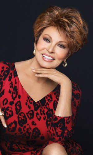 Woman with short, voluminous hairstyle wearing a red leopard print dress.