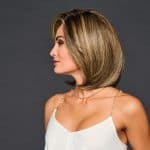 Side view of a woman with a sleek blonde bob wig and natural makeup.