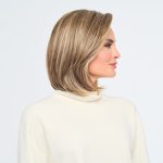 Side view of a woman with a sleek blonde bob wig.