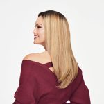 Long blonde wavy wig styled on a woman with a side profile view.