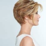 Side view of a woman with a stylish short blonde wig and natural makeup.