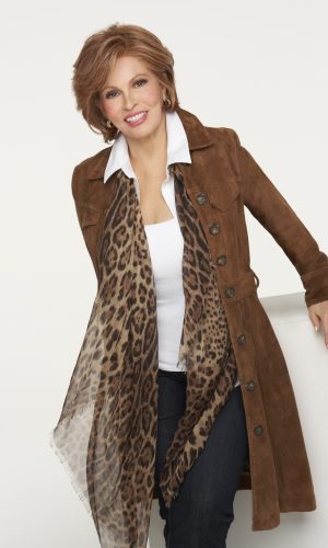 Smiling woman wearing a brown coat and leopard print scarf, posing confidently.