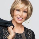 Stylish short blonde wig on a smiling woman with hoop earrings.