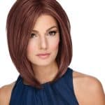 Woman with shoulder-length auburn bob wig, natural makeup, blue top.