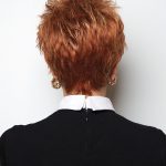 Short curly red wig styled for a bold, powerful appearance.