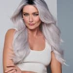 Woman with long silver ombre wavy wig and white tank top.