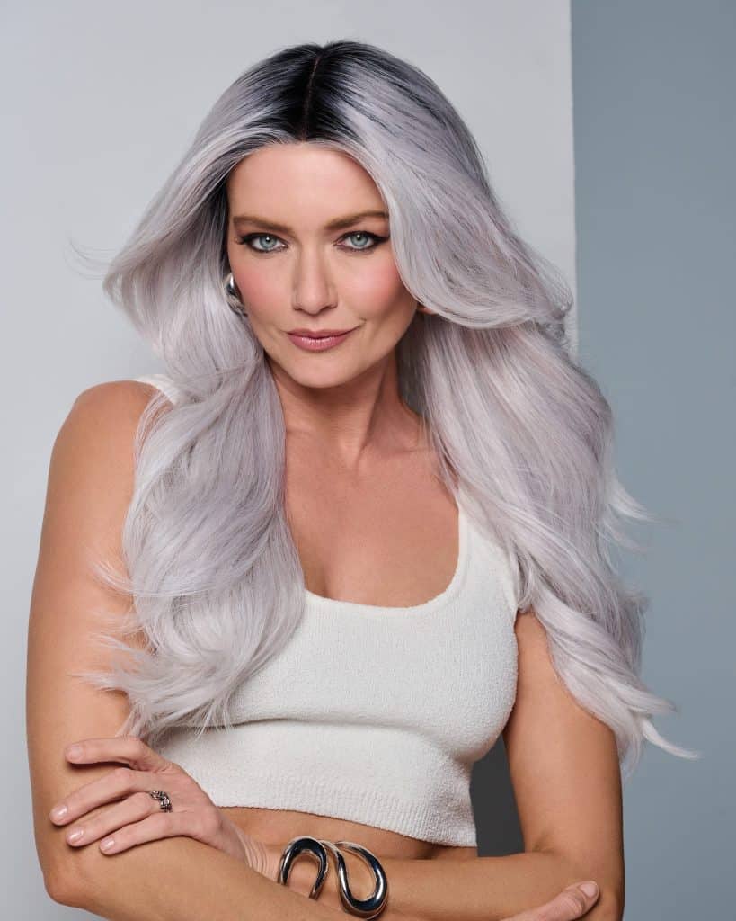 Woman with long silver ombre wavy wig and white tank top.