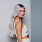 Woman with long silver ombre wavy wig and white outfit.