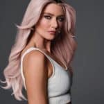 Blonde wavy wig with soft curls, styled on a woman with fair skin and blue eyes.