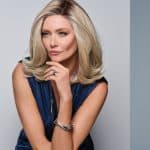 Beautiful blonde wig styled on a woman with soft waves and natural look.