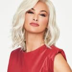 Blonde wavy wig styled on a woman with a confident expression.