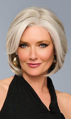 Woman with stylish silver bob wig and hoop earrings, smiling confidently.