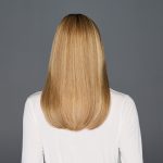 Back view of a blonde straight wig on a woman with white top.