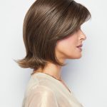 Side view of a woman wearing a short, layered brown wig with a natural shine.