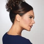 Beautiful woman with elegant curly updo wig and side profile view.
