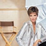 Woman with short pixie wig in a studio setting with lighting equipment.