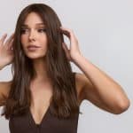Beautiful woman with long, wavy brown hair wearing a dark top.