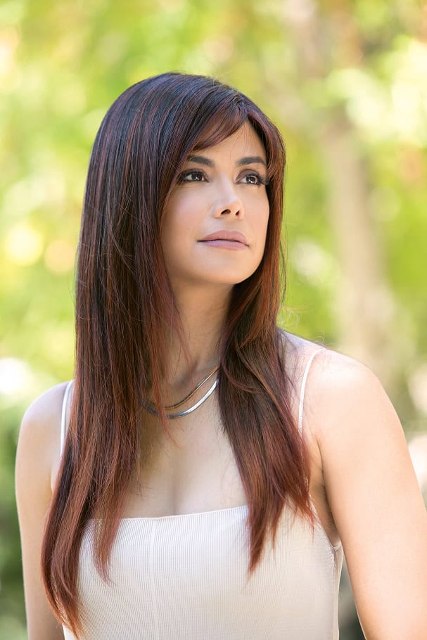 Woman with long, straight, brown hair in an outdoor setting.