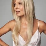 Blonde long layered wig with side-swept bangs on a woman.