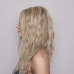 Blonde wavy wig showcased on a side profile model for Hidden Secrets Wigs.