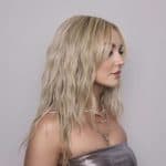 Blonde wavy wig styled on a woman for elegant look.