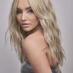 Blonde wavy wig model from Hidden Secrets Wigs for elegant looks.