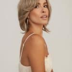 Stylish woman with blonde layered wig from Hidden Secrets Wigs.