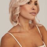 Blonde wavy wig styled on a woman with a neutral background.