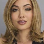 Blonde layered wig with side parting, styled for a natural look.