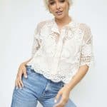 Stylish woman with short platinum blonde wig and casual outfit.