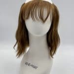 Wavy bob wig with bangs on a mannequin head for fashion and styling.
