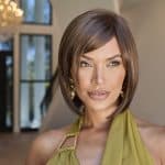 Elegant woman with short brown wig in modern interior setting.