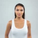 Elegant woman with long, straight, dark hair wearing a white tank top.