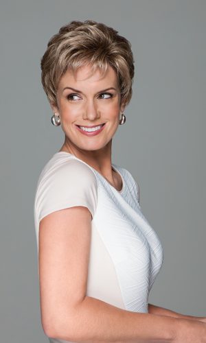 Short wavy wig on smiling woman with short hair and earrings.