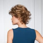 Short curly wig in light brown on a woman with side profile.