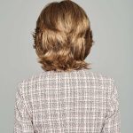 Back view of a woman with a short, layered, light brown wig.