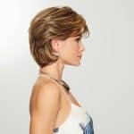 Side view of a woman wearing a short, wavy, light brown wig with layered styling.