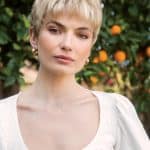 Short blonde wig with layered style on a woman outdoors.
