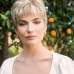 Short blonde wig with textured layers on a woman outdoors.