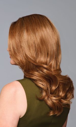 Side view of a woman with long, wavy auburn wig.