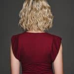 Blonde wavy wig displayed from the back on a woman in a red top.