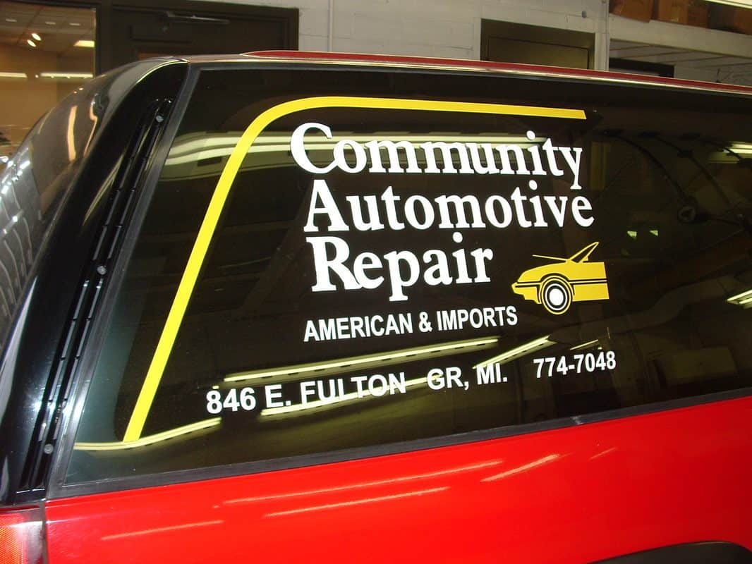 Automotive repair shop window decal with contact info and logo.