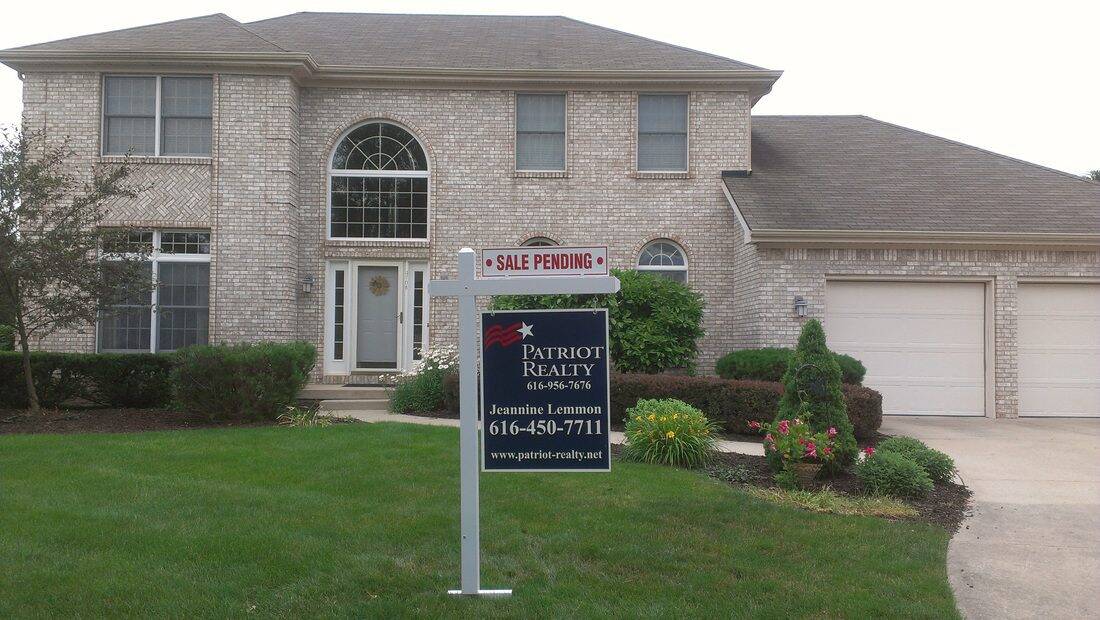 Two-story house with sale pending sign in front yard and well-maintained landscaping.